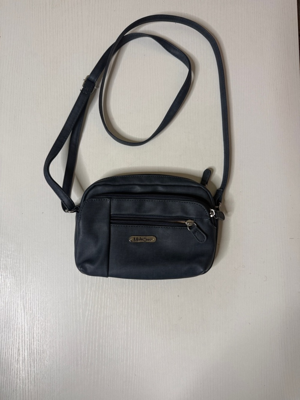 Compact black leather-look crossbody with front zip pocket